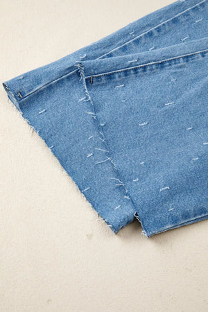 Blue denim jeans with distressed details and raw hem