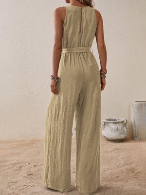 Tan textured wrap-front wide-leg jumpsuit with belted waist and sleeveless design.