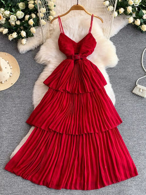 Red belted midi dress with spaghetti straps, tiered pleated skirt and V-neck bodice.