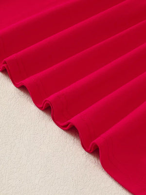 Red baby dress fabric detail with subtle texture and wavy hem