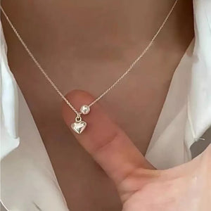 Delicate silver heart pendant necklace with pearl accent on chain