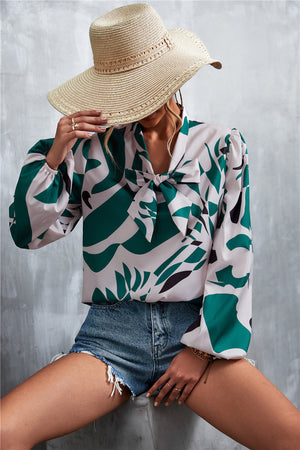 Abstract print pussy bow blouse in green and white with balloon sleeves.
