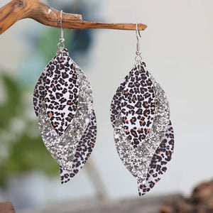 Leopard print layered drop earrings with glitter accents, gold and silver tones.