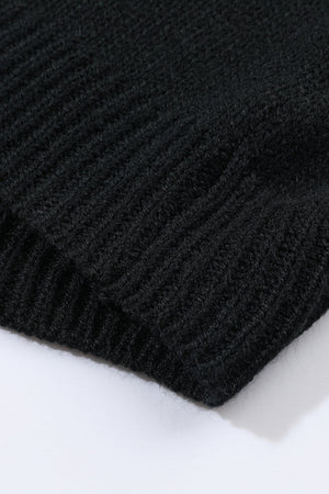 Black acrylic knit cardigan detail showing ribbed texture and hem