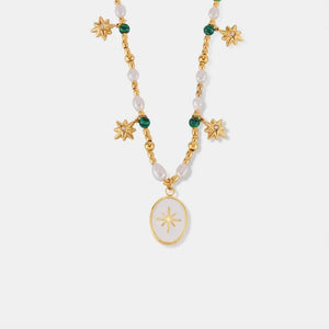 Gold celestial necklace with pearls, green beads, starburst charms and oval pendant.