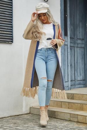 Khaki long cardigan with geometric trim and fringe hem, worn with ripped jeans.