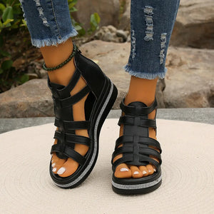 Black gladiator wedge sandals with crystal trim detail on the sole.