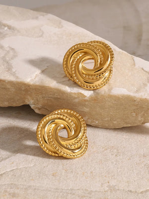 Gold swirl knot stud earrings with textured edge detail.