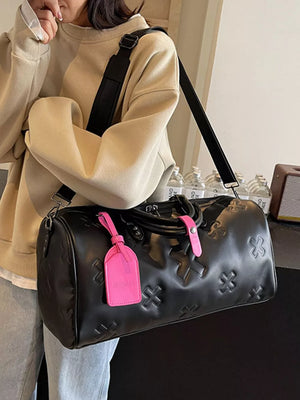 Black embossed cross detail luxury duffel bag with pink luggage tag