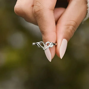 Silver ring with engraved heart hands design