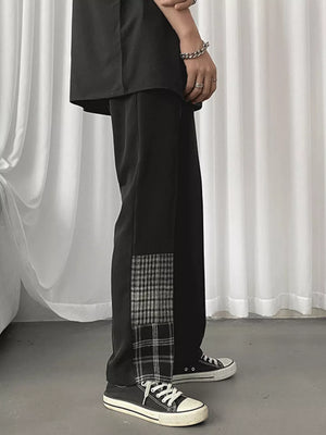 Men's black straight-leg chinos with plaid patchwork detail on the side.