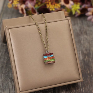 Stacked prism charm necklace with multicolor stacked blocks and antique gold chain.