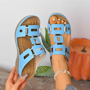 Sky blue open-toe wedge sandals with cut-out straps and gold accents.