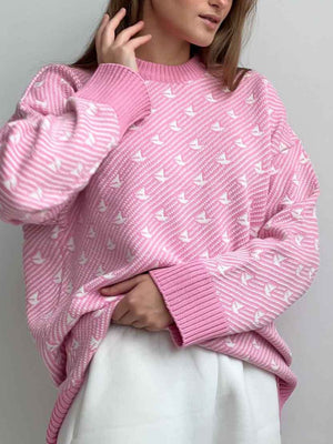 Blush pink knit sweater with white sailboat pattern and striped cuffs.