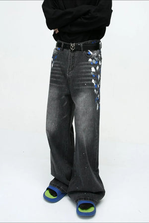 Dark wash wide leg jeans with artistic brushstroke details and paint splatters.