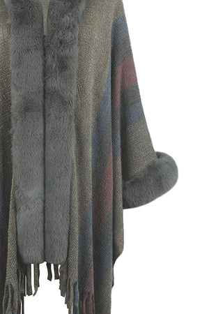 Textured stripe poncho with faux fur trim and cuffs, featuring fringe detail.