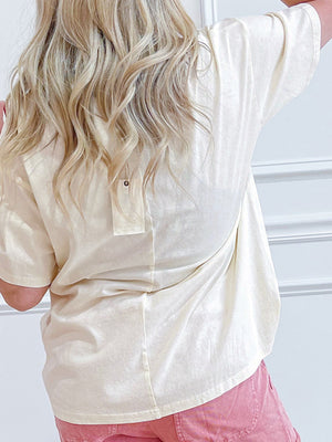 Cream t-shirt with stud detail pocket on back, short sleeves, and relaxed fit.