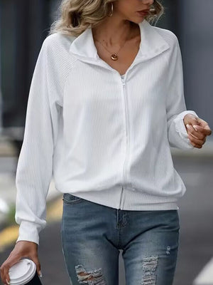 White ribbed zip-up jacket with raglan sleeves and a stand-up collar.