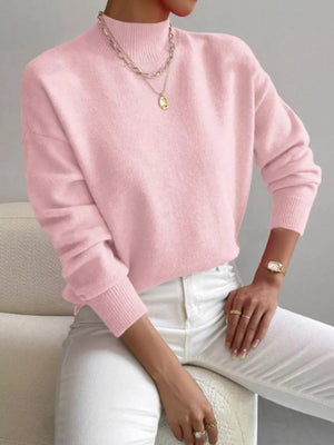 Pink mock neck knit sweater with dropped shoulders, acrylic material, and ribbed cuffs.