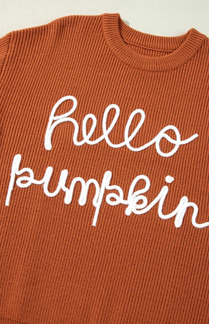 Terracotta knit sweater with white "hello pumpkin" script detail.