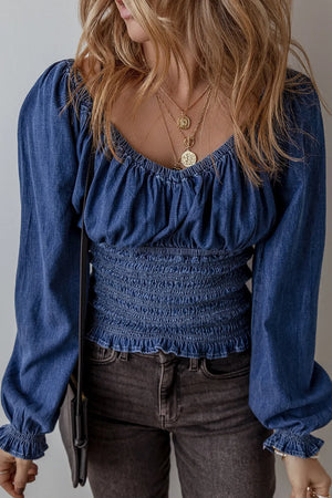 Medium wash denim corset bodice blouson top with smocked waist and blouson sleeves.