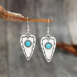 Silver heart-shaped earrings with turquoise stones and decorative etching.