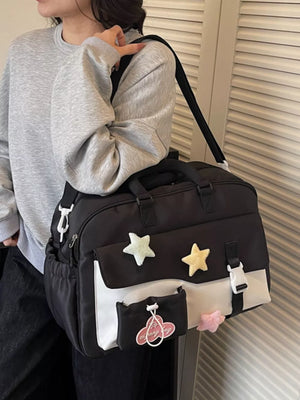 Black and white color block travel bag with star embellishments and a pink cloud tag.