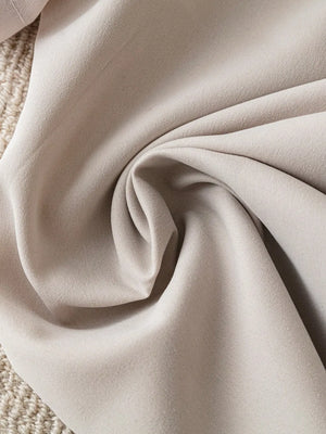 Short-sleeve blazer jacket in light khaki fabric with a textured weave detail.
