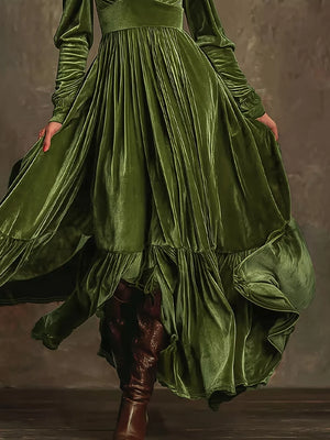 Dark green velvet maxi dress with voluminous sleeves and ruffled hem.