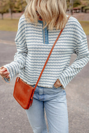 Textured stripe henley sweater in dusty blue with button neckline and relaxed fit.