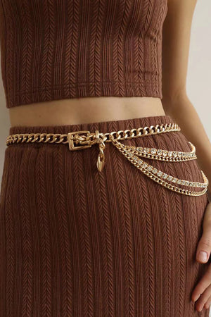 Gold layered chain belt with rhinestone embellishments and a heart charm.
