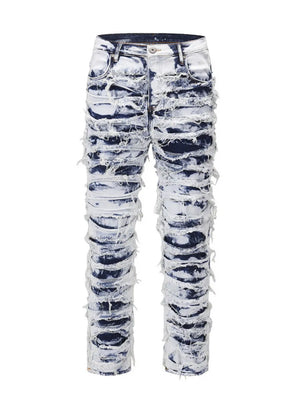 Distressed shredded denim jeans in medium wash with artistic sculptural details.