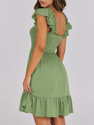 Sage green smocked mini dress with ruffle trim and flutter sleeves.
