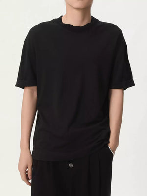 Black cotton t-shirt with round neck and cuffed short sleeves.