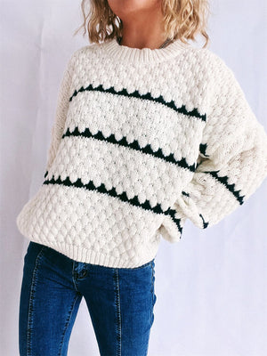 White acrylic knit jumper with black chevron stripes and textured diamond pattern.