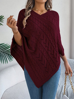 Burgundy cable knit poncho with chevron detail and V-neck, styled with jeans.
