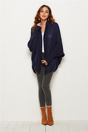 Textured cocoon knit cardigan in dark blue with batwing sleeves and shawl collar.