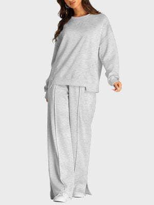Light gray seamed loungewear set with crewneck sweatshirt and slit-front wide-leg trousers.
