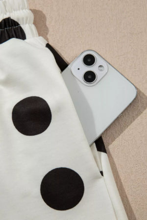 Polka dot lounge set with elastic waist and side pocket holding a phone.