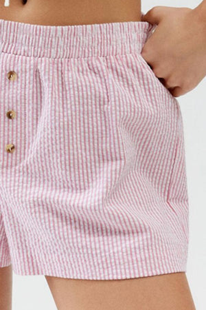 Pink seersucker boxer shorts with button detail and elastic waistband.