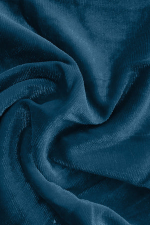 Plush velvet wide-leg trousers in deep teal with subtle ribbed texture.