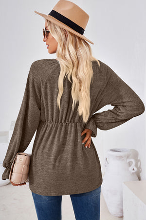 Mocha knit blouse with cinched waist, long balloon sleeves, and ruffled cuffs.