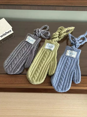 Gray, green, and blue cable knit acrylic mittens with braided cords.