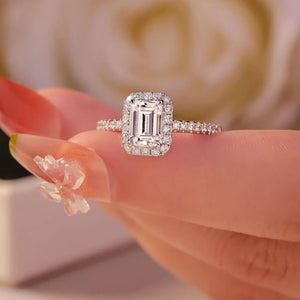 Radiant moissanite engagement ring in silver with emerald-cut center stone and halo.