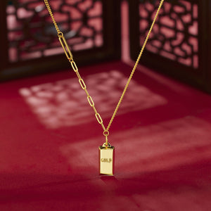 Gold-plated bar pendant necklace with curb link chain detail.