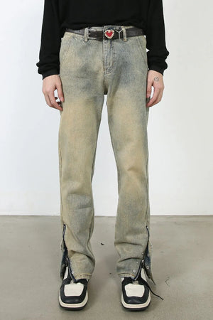 Distressed denim jeans in light wash with split hems and zippers.