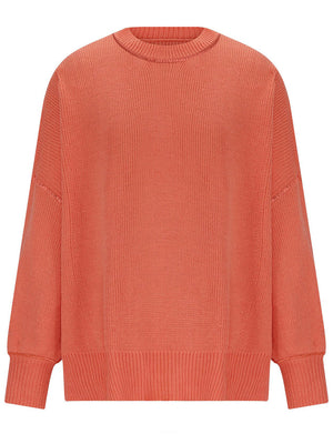 Oversized ribbed knit sweater in orange-red with drop shoulders and crew neck.