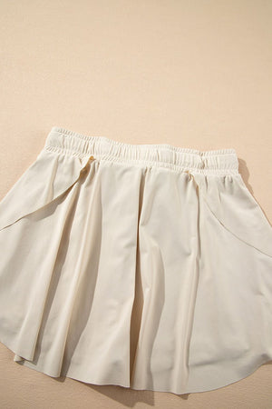 Beige ruffled skort with elastic waist and tie detail