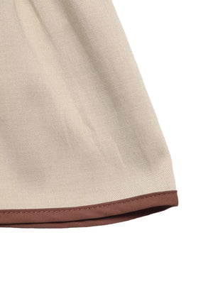 Charming V-neck blouse in beige with brown trim detail on the hem.