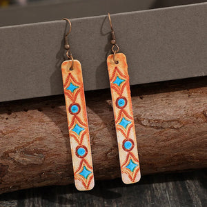 Tangerine embroidered leather dangle earrings with blue diamond and circle pattern